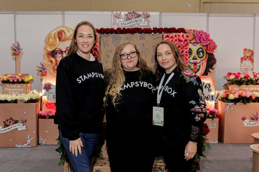 Tres del equipo de Stampsybox con sudaderas de la marca en el stand